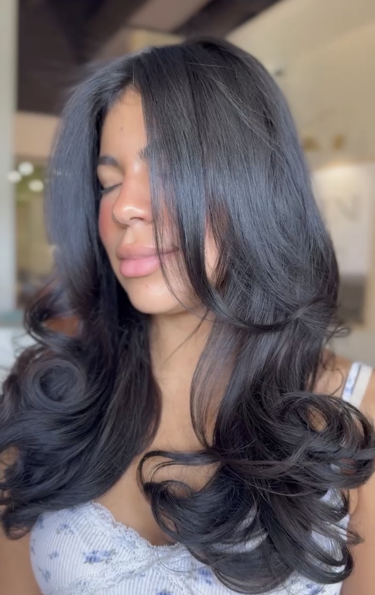 Glossy dark layered haircut with a bouncy finish by Aaliyah at AMAVI Salon
