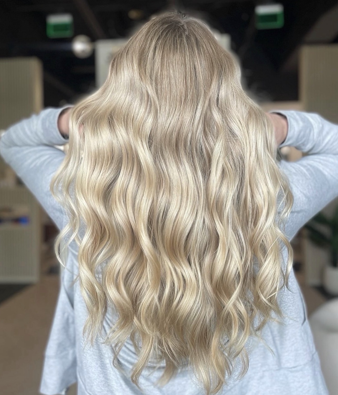 Soft dimensional blonde with flowing waves by Ariella at AMAVI Salon